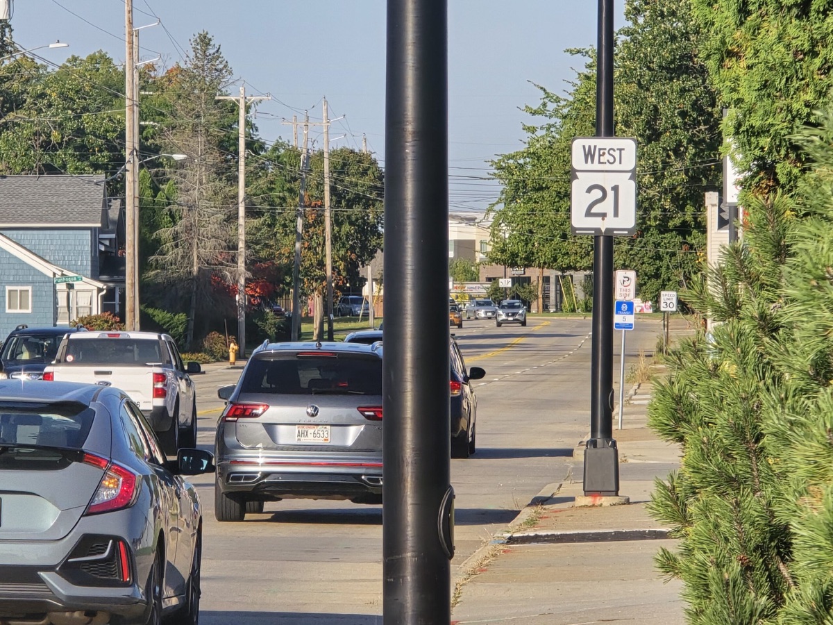 Cars and trucks on a worn Wisconsin roadway in need of repair